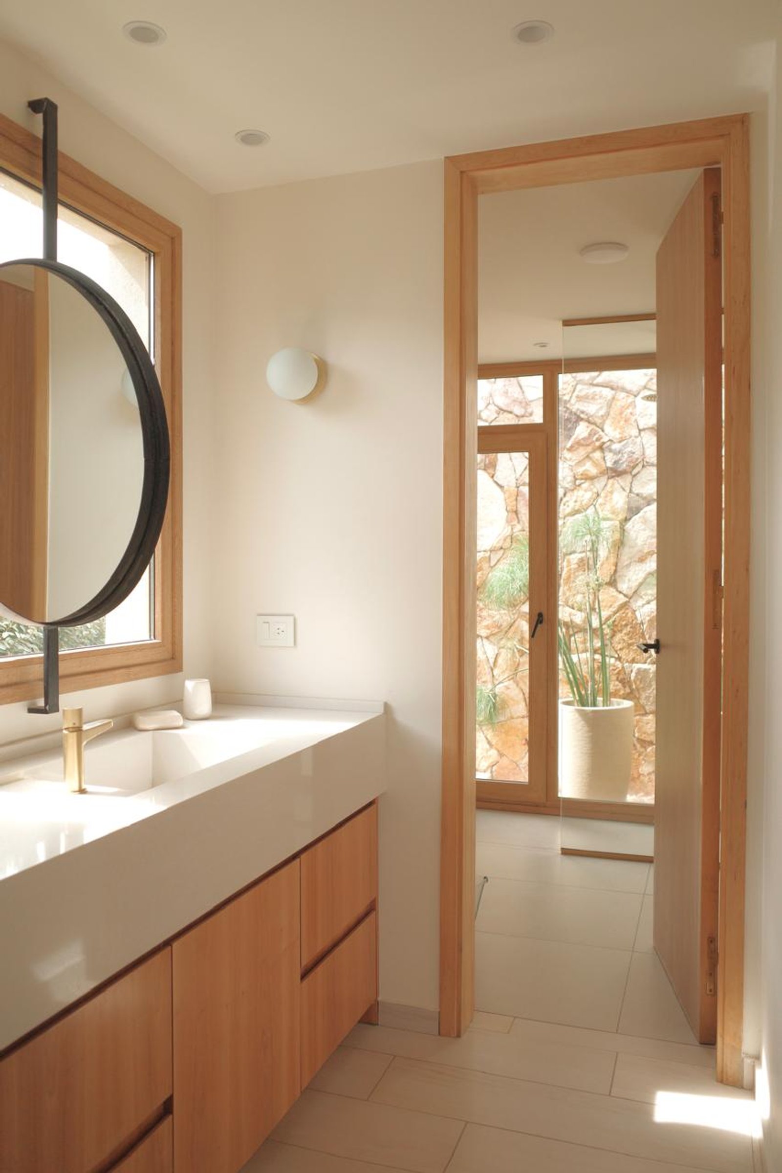 Baño moderno con mueble de madera y grifería dorada — proyecto Casa Refugio, por Jeitinho Estudió Creativo, en Neuquén